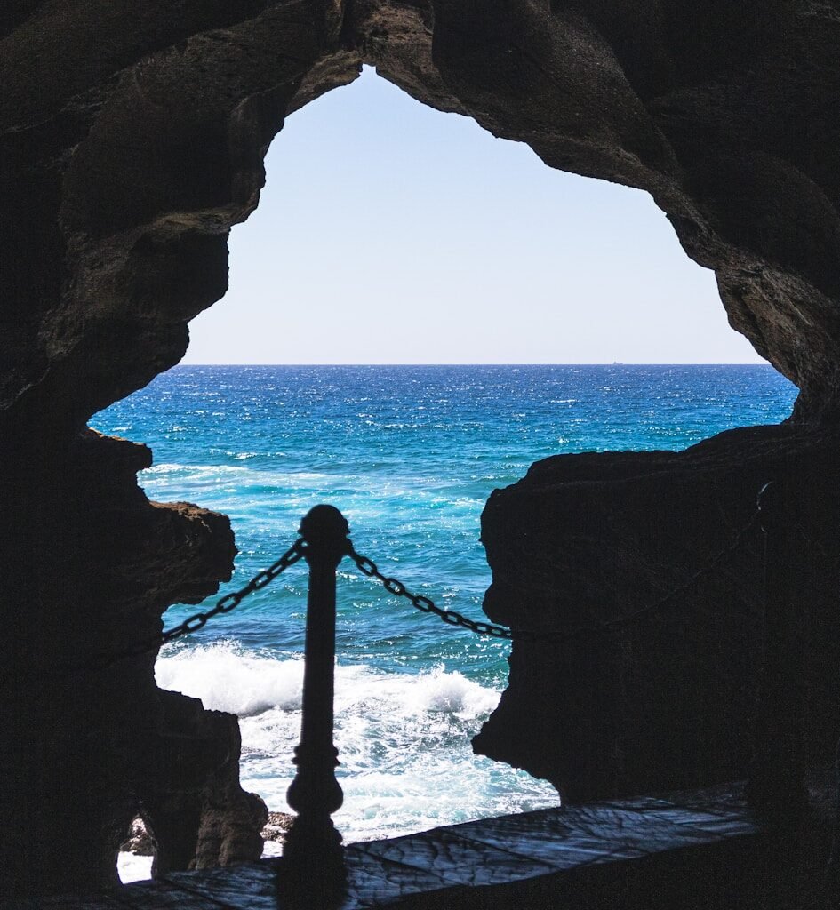 a view of a body of water from inside a cave