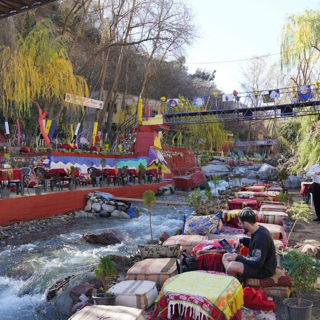 a group of people sitting at a table next to a river
