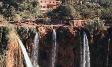 a large waterfall with a bridge above it