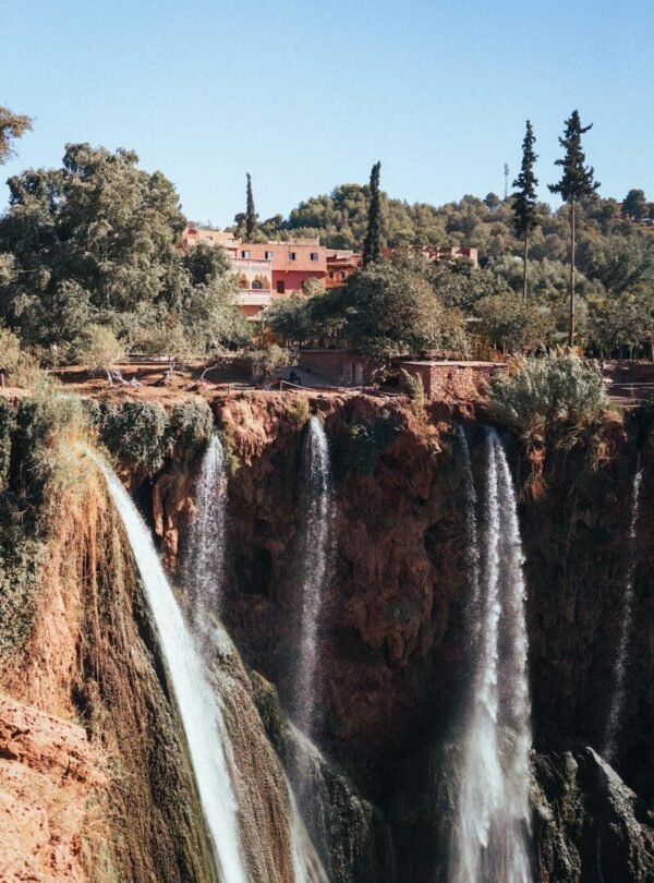 a large waterfall with a bridge above it